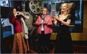  ?? DANA JENSEN/THE DAY ?? Lisa Tener, left, of Saundersto­wn, R.I., takes a photo of her friend, actress Margaret Curry, right, in the lobby of Mystic Luxury Cinemas on Thursday’s opening night of the Mystic Film Festival. Curry was taking a photo of Sophia Colon Roosevelt and Linnette Roe, her fellow actresses in the movie “Starfish,” which was shown that night in the theater. At center is Curry’s sister-in-law, Oonagh Hamill, of Wayne, N.J.