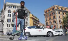  ?? (Max Rossi/Reuters) ?? CHRISTIAN OKORO of Nigeria sweeps a street in downtown Rome on May 18.