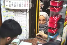  ??  ?? Buying lottery tickets at the Nimet Abla lottery stand even as criticism rain down on the buyers for “sinning”.