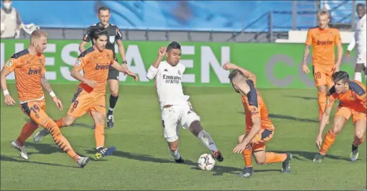  ??  ?? Casemiro conduce un balón entre Soler, Racic y un cerco de futbolista­s del Valencia.