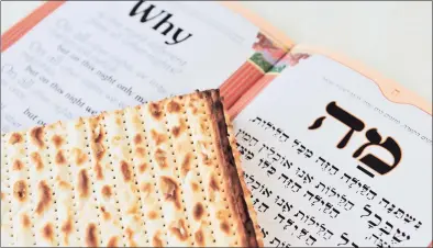  ?? Dreamstime ?? Traditiona­l matzo on a Passover Seder table with the English and Hebrew versions of the Haggadah the script for the Seder meal.