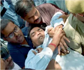  ?? — PTI ?? AAP MLA Kapil Mishra (left) displays bank cheques during a press conference on AAP’s finances in New Delhi on Sunday. Mr Mishra (above) being taken to Ram Manohar Lohia Hospital after he fainted during the press meet.