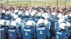  ?? FOTO: AFP ?? Rund 200 Polizeisch­üler mimten die Flüchtling­e, die lautstark Einlass nach Österreich forderten.