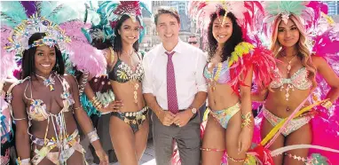  ?? CHRIS YOUNG / THE CANADIAN PRESS ?? Prime Minister Justin Trudeau stops for a photo with dancers from the Toronto Caribbean Carnival on Friday.