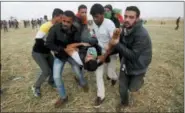  ?? ADEL HANA — THE ASSOCIATED PRESS ?? Palestinia­n protesters evacuate a wounded youth during clashes with Israeli troops along the Gaza Strip border with Israel, east of Khan Younis, Gaza Strip, Friday.
