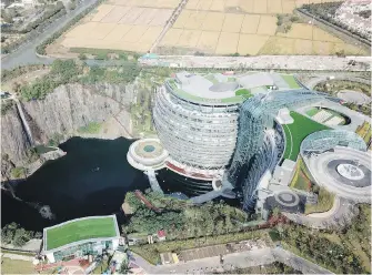  ??  ?? The 18-storey Interconti­nental Shanghai Wonderland Hotel in the Songjiang district of Shanghai has been built into the side of a huge hole in the ground left by a former pit mine.