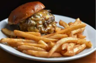  ?? PHOTOS BY JOSH REYNOLDS FOR THE BOSTON GLOBE ?? An order of pierogies with assorted fillings, a Fire Fox cocktail with a togarashi spiced rim, and a burger and fries at The Fox Den in Woburn.