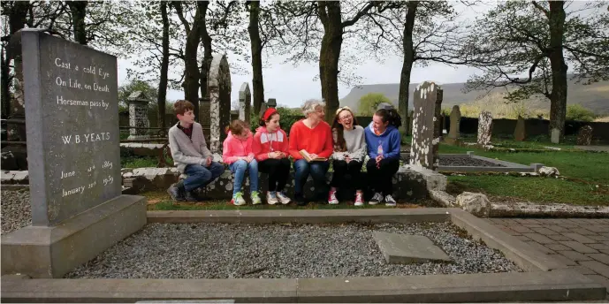  ?? Pic: Brian Farrell ?? Inaugural Yeats Society Sligo poet-in-residence Alice Lyons reading poetry to a group of Sligo primary schoolchil­dren at Yeats’s grave in Drumcliffe, Sligo.