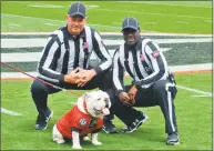  ?? Gary McGriff / Associated Press ?? Officials Phillip Davenport, left, and Grantis Bell pose with Georgia mascot Uga at Georgia’s April 20 spring game in Athens, Ga.