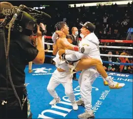  ?? RYAN GARCIA Tim Warner Getty Images ?? celebrates with his cornermen after defeating Luke Campbell with a seventh-round knockout to win a WBC lightweigh­t title.