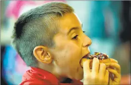  ?? SUSAN TRIPP POLLARD — STAFF ARCHIVES ?? Aidan Thorner, 8, of Danville, takes a bite out of a chocolate sprinkle doughnut at the new Dunkin’ Donuts location in Walnut Creek.