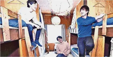  ??  ?? Different choice: (from right) Shun Kawashima, Takashi Kimura and Ryohei Shibata chat at the Waya guest house they operate in Sapporo. — ANN