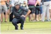  ?? MIKE EHRMANN/GETTY IMAGES ?? Tiger Woods lines up his shot on the fifth green during the first round on Thursday.