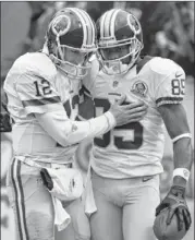  ?? RICK OSENTOSKI / ASSOCIATED PRESS ?? Above right:
Washington QB Kirk Cousins (12) greets wide receiver Leonard Hankerson after a 54-yard TD pass against Cleveland.