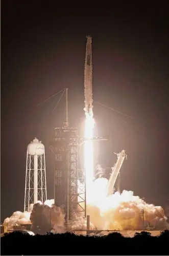  ?? John Raoux / Associated Press ?? A Spacex Falcon 9 rocket with the Crew Dragon capsule lifts off Wednesday night from Launch Pad 39A at the Kennedy Space Center in Cape Canaveral, Fla.