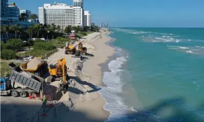  ?? Photograph: Joe Raedle/Getty Images ?? The US army corps of engineers distribute­s sand along the beach in Miami Beach, Florida. The project is part of a $16m scheme to widen the beaches in an effort to fight erosion and protect properties from storm surges.