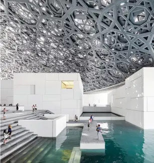 ??  ?? ABOVE
Louvre Abu Dhabi’s stunning stainless steel and aluminium dome achieves a simple objective – to shade and protect visitors, while delicate patterns of light dance across the vast horizontal and vertical planes. Visitors can walk along the water channels that surround the museum and behold Jean Nouveau’s shimmering dome that encases the main gallery spaces, its pattern of some 8,000 geometric stars filtering a ‘rain of light’ throughout the day.