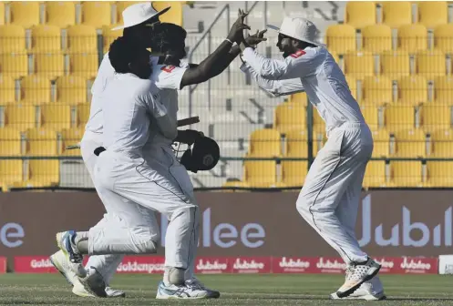  ??  ?? 0 Sri Lanka’s Rangana Herath, right, celebrates with team-mates after their win on the fifth day of the first Test against Pakistan.