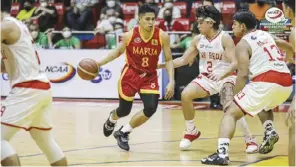  ?? ?? Mapua University Cardinals’ Brian Lacap dribbles the ball while being defended by three San Beda University Red Lions players.