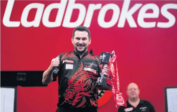  ??  ?? Jonny Clayton lifts the trophy after beating Mervyn King to win the Ladbrokes Masters at the Marshall Arena in Milton Keynes.