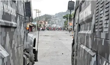  ??  ?? Riot police members and soldiers clash with supporters of Nasralla during protests in Tegucigalp­a. — AFP photo