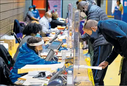  ?? MICHAEL REYNOLDS / EFE ?? •
En Lanham, en el estado de Maryland, y protegidos por vidrios, los votantes acudieron ayer a depositar el voto para Presidente.