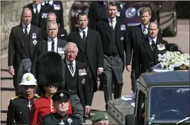  ?? LEON NEAL-ASSOCIATED PRESS ?? From front left, Britain’s Prince Charles, Prince Andrew. Prince Edward, Prince William, Peter Phillips, Prince Harry, Earl of Snowdon and Tim Laurence follow the coffin the coffin makes it’s way past the Round Tower during the funeral of Britain’s Prince Philip inside Windsor Castle in Windsor, England Saturday.