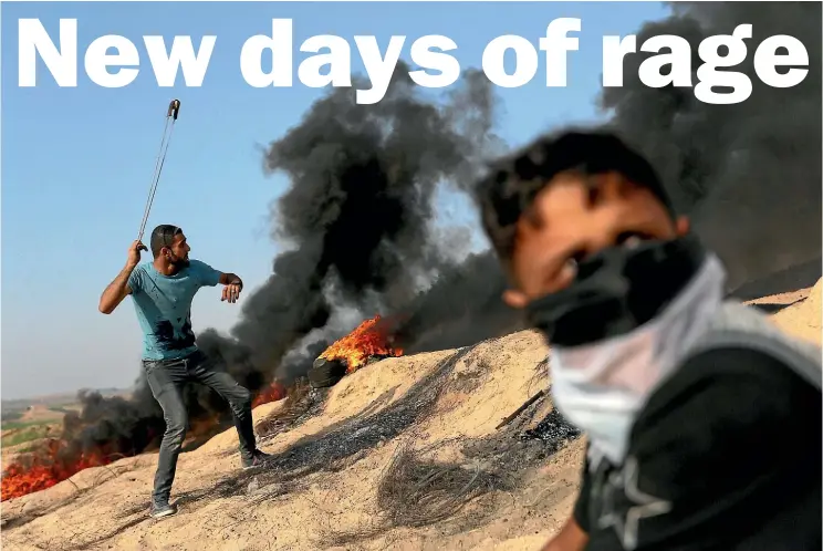  ??  ?? A Palestinia­n protester uses a sling to hurl stones at Israeli troops during clashes near the border between Israel and the central Gaza Strip.