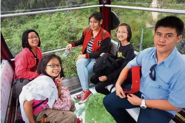  ??  ?? (From left) Athena, Amelia, Gabrielle Ann, Xiang Lin and Bryan enjoying the Awana SkyWay cable car ride that offered them a bird’s eye view of the forest at Genting Highlands.