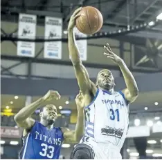  ?? JULIE JOCSAK/STANDARD STAFF ?? Kirk Williams Jr. of the Niagara River Lions takes a shot at the net past Flenard Whitfield of the Kitchener-Waterloo Titans in basketball action at Meridian Centre in St. Catharines Thursday.