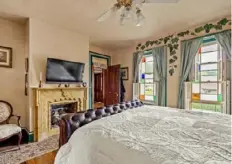  ?? ?? This bedroom has an original fireplace and stained-glass windows.