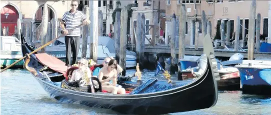  ?? PHOTOS: KEVIN BISSETT/THE CANADIAN PRESS ?? Tourists explore the canals of Venice, Italy. Leave the planning to a motor coach company and focus on taking in the sights.