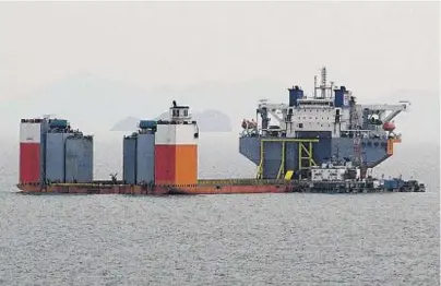  ??  ?? WORKS: A semi-submersibl­e vessel awaits to salvage the sunken Sewol ferry in waters off Jindo yesterday