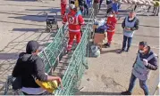  ?? AFP) ?? A migrant woman (left) disembarks from a rescue ship in Taranto on Wednesday (