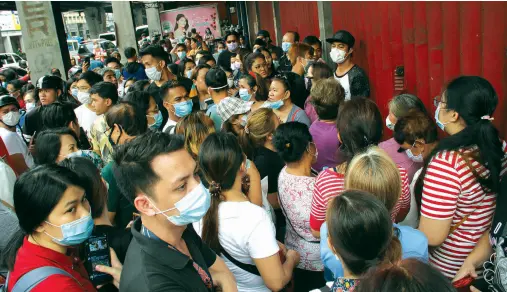  ??  ?? PEOPLE queue up in front of medical supply stores on Rizal Avenue corner Remigio Street in Sta. Cruz, Manila to purchase face masks as protection against the novel coronaviru­s (2019-nCoV). There has been panic buying of face masks since the Department of Health confirmed the first case of nCoV in the country. PNA photo