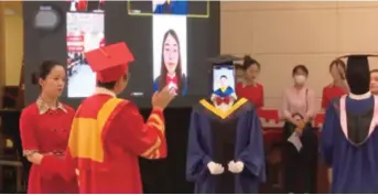  ??  ?? A graduating student is ready to receive his diploma via video link with the help of a robot at the cloud graduation ceremony of the Nanjing University of Posts and Telecommun­ications on May 22