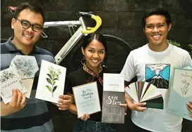  ?? RETNO DYAH/JAWA POS ?? SIMPEL: Dari kiri, Yohanes Surya Kusuma, Saraswati Ayu Indhiraswa­ri, dan Bayu Priyo Putranto menunjukka­n beragam desain undangan dengan variasi kertas.