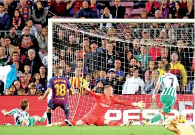  ?? — Gambar Reuters ?? CANALES (kiri) menjaringk­an gol keempat Betis pada perlawanan La Liga Sepanyol menentang Barca di Nou Camp, Barcelona Ahad lepas.