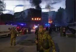  ?? David Guttenfeld­er/The New York Times ?? Soldiers and first responders at the site of a missile strike in Kyiv, Ukraine, April 28.