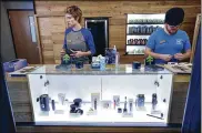  ?? STEVEN SENNE/AP ?? Associates Savannah Stuitje and Josh Hirst stand at a counter featuring vape dispensers at a medical marijuana dispensary in Northampto­n, Mass.