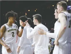  ?? The Associated Press ?? CELEBRATE WITH TEAMMATES: Michigan guard Jordan Poole (2) celebrates with teammates at the end of a second round men’s college basketball game against Florida in the NCAA Tournament, Saturday, in Des Moines, Iowa. Michigan won 64-49.