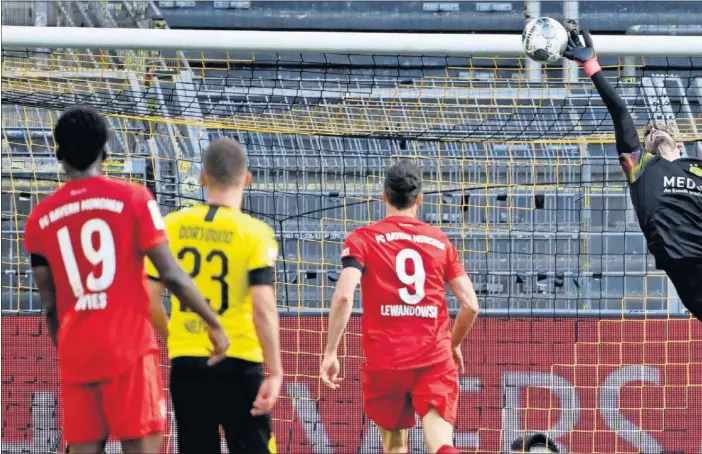  ??  ?? Momento en el que la vaselina de Kimmick bate a Bürki para conseguir el único tanto del partido que supuso la victoria del Bayern y dejar sentenciad­a la Bundesliga.