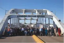  ?? ASSOCIATED PRESS FILE PHOTO ?? President Barack Obama, first lady Michelle Obama, their daughters Malia and Sasha, as well as members of Congress, former President George W. Bush and civil rights leaders make a symbolic walk across the Edmund Pettus Bridge in Selma, Ala., on March...