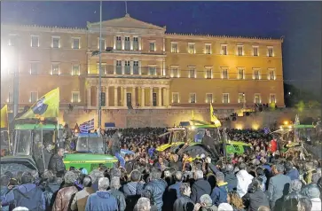  ?? ASSOCIATED PRESS ?? Farmers drive their tractors during a protest Friday in front of the Greek parliament in Athens. The two-day protest is against the government and its plans to impose new tax hikes and pension charges.