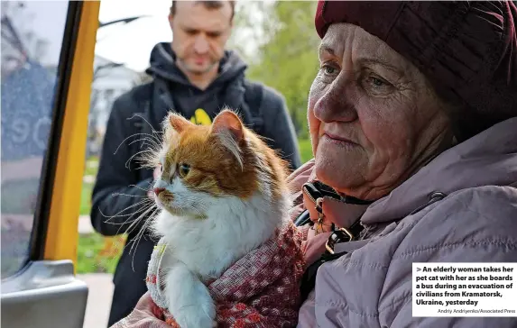  ?? Andriy Andriyenko/Associated Press ?? An elderly woman takes her pet cat with her as she boards a bus during an evacuation of civilians from Kramatorsk, Ukraine, yesterday