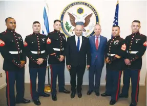  ?? (David Azagury) ?? PRIME MINISTER Naftali Bennett and US Chargé d’Affaires Michael Ratney with members of the Marine Guard at the US Embassy in Jerusalem on Monday.
