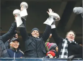  ?? AP PHOTO ?? New England Patriots quarterbac­k Tom Brady holds up Super Bowl trophies along with head coach Bill Belichick, right, and team owner Robert Kraft, left, during a rally yesterday in Boston.