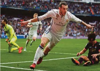  ??  ?? Bale meraikan gol jaringanny­a ketika menentang Espanyol di Santiago Bernabeu, semalam.