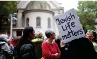  ?? (Liesa Johannssen/Reuters) ?? PEOPLE ATTEND a vigil in front of the Fraenkeluf­er Synagogue in Berlin in October last year.