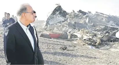  ?? — Gambar Reuters ?? TRAGIK: Ismail melihat bangkai Airbus A321 Metrojet Kogalumavi­a yang terhempas di kawasan pergununga­n tengah Semenanjun­g Sinai dekat bandar raya utara El Arish, kelmarin.
